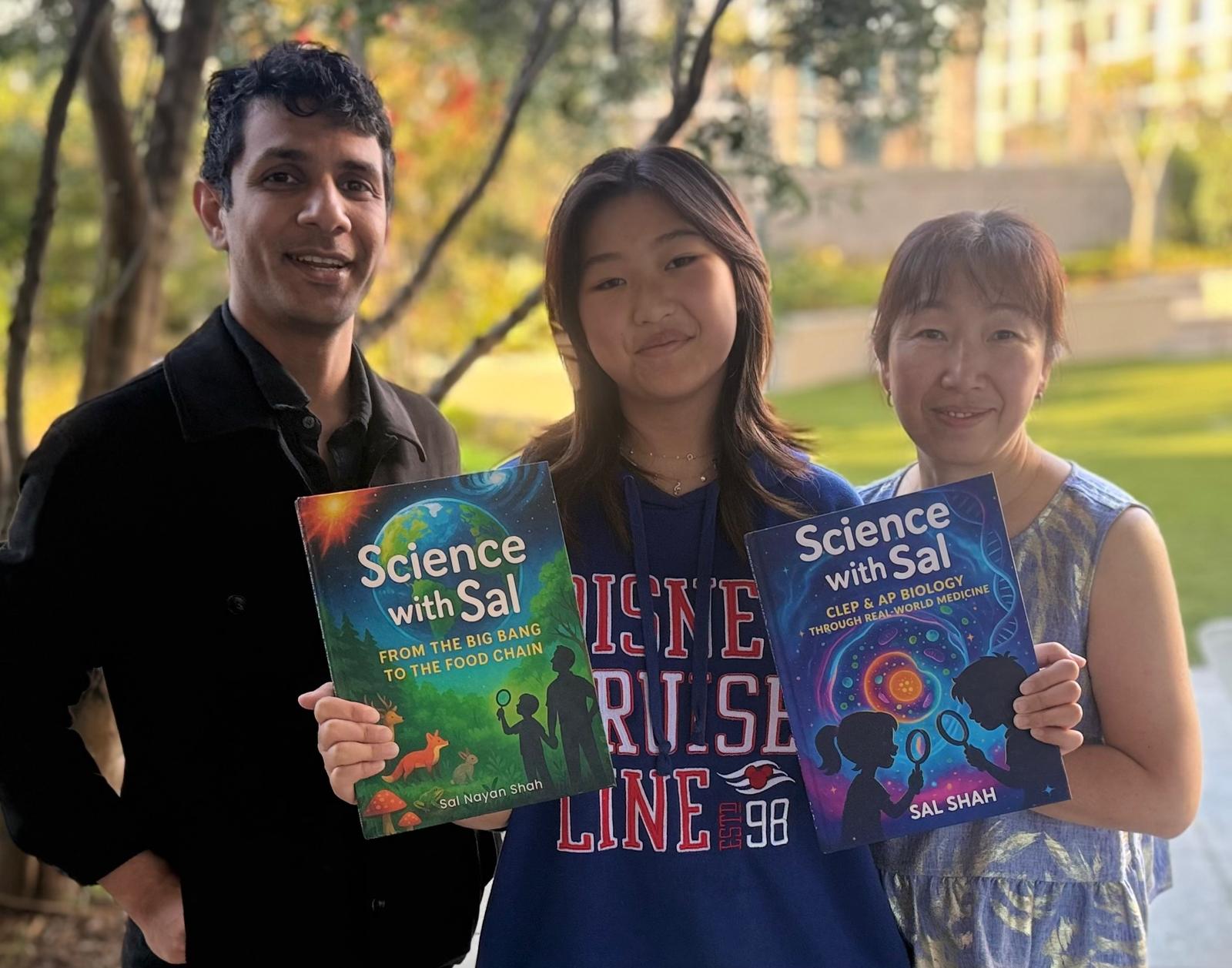 Sal Shah with a student, holding Science with Sal: Discover